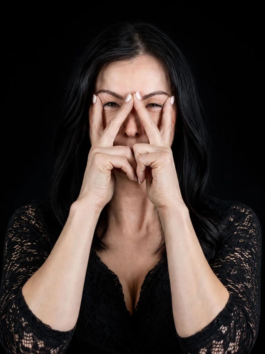 Christine Scheib demonstriert eine FACE-Übung mit den Händen im Gesicht